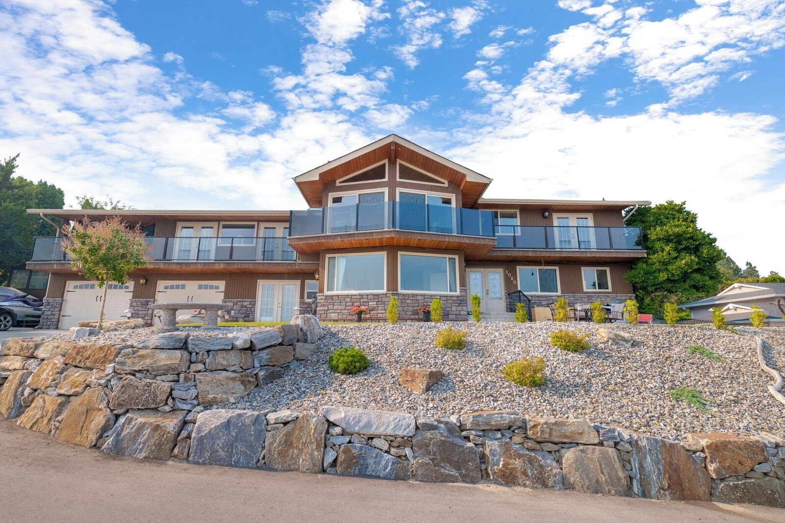 Front exterior of the house with stone facade and terraced landscaping