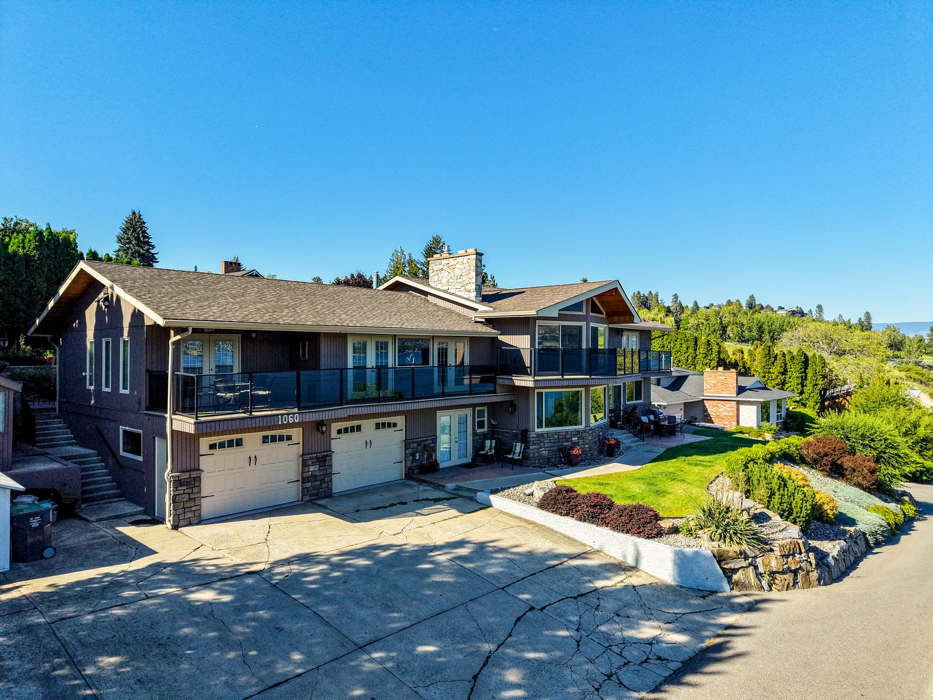 Drone aerial of property showing balcony, exterior and glass railing overlooking the neighbourhood