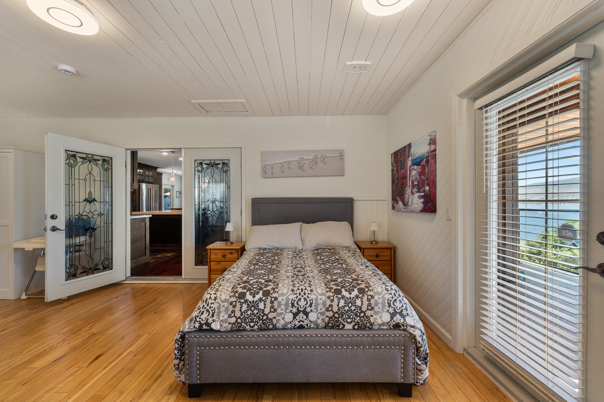 Queen bedroom second angle showing stained glass doors and lake view