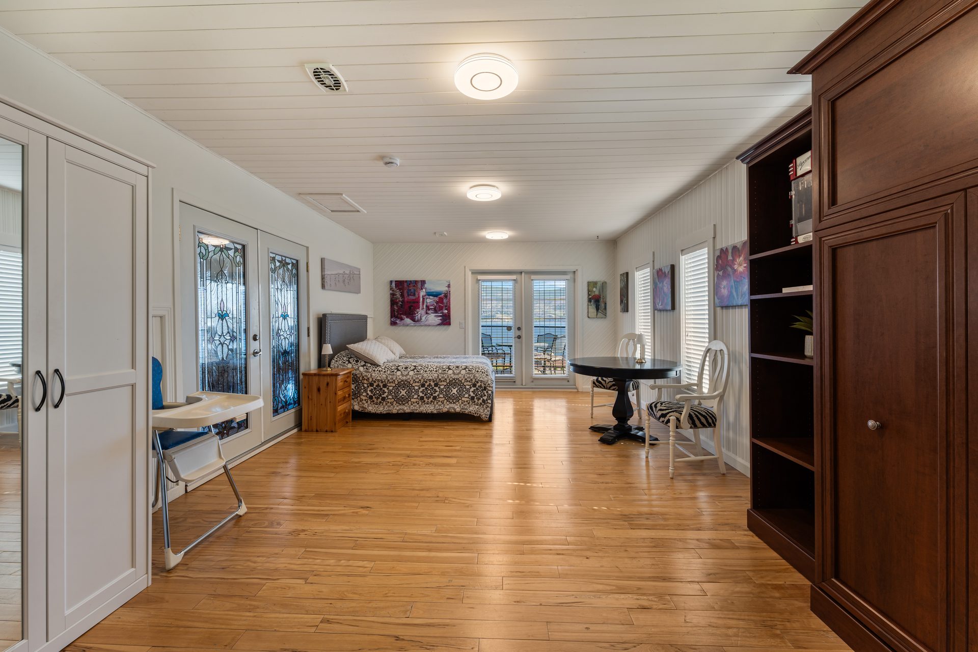 Spacious lower level suite with queen bed, sitting area, stained glass doors and lake view