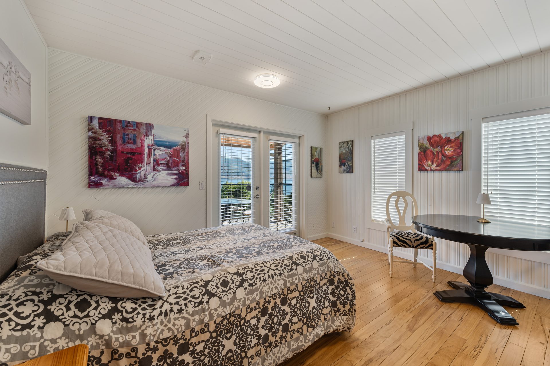 Lower suite wide angle showing bedroom, sitting area, bookcase and entry