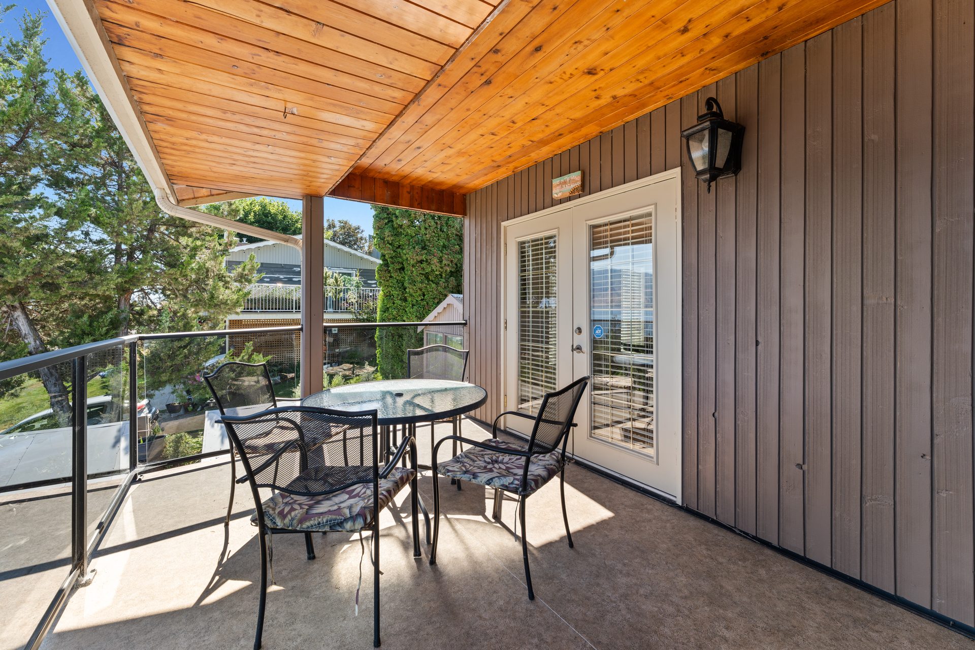 Long covered balcony with outdoor seating and Okanagan Lake views along the full length