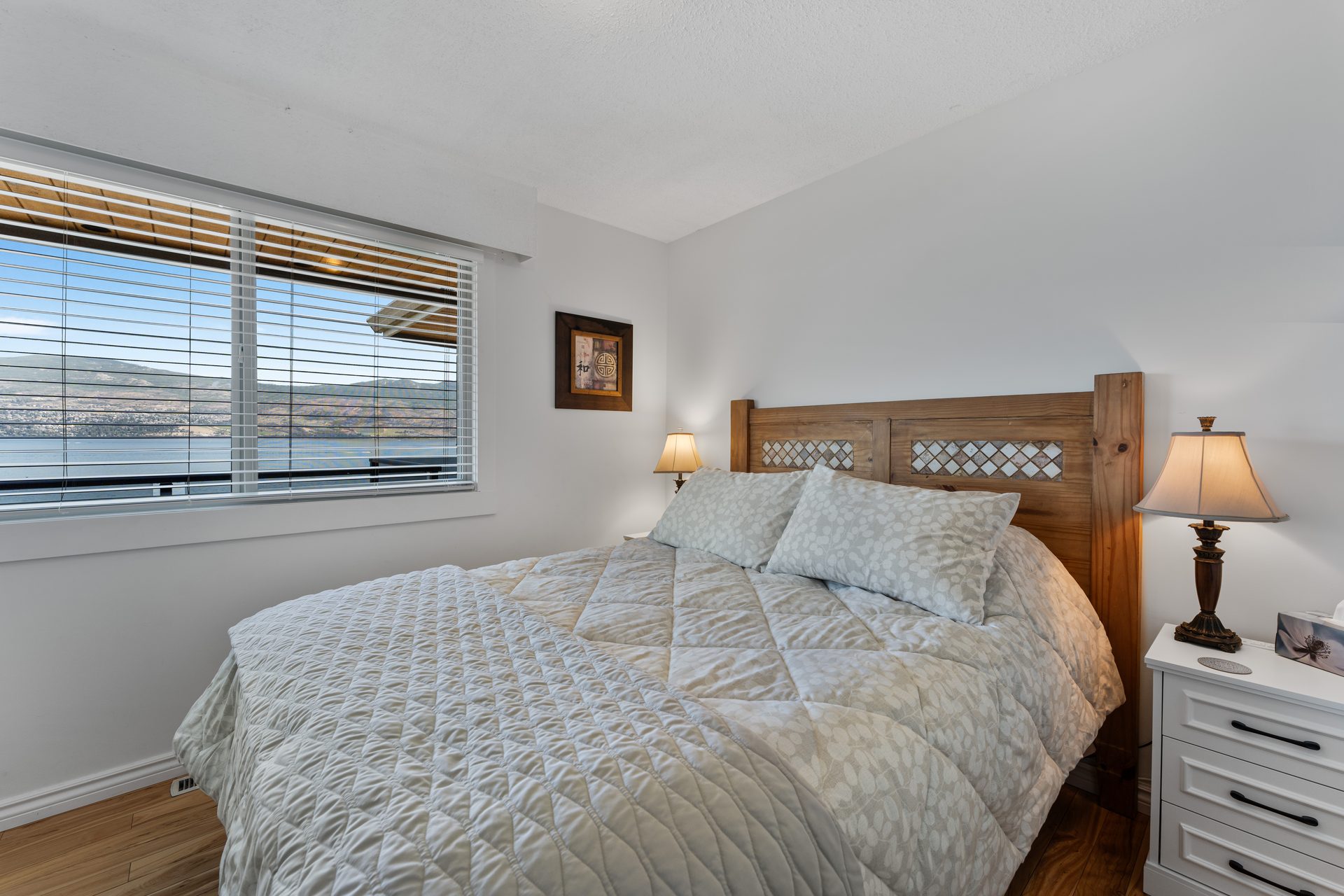Queen bedroom with ceiling fan and garden-view window