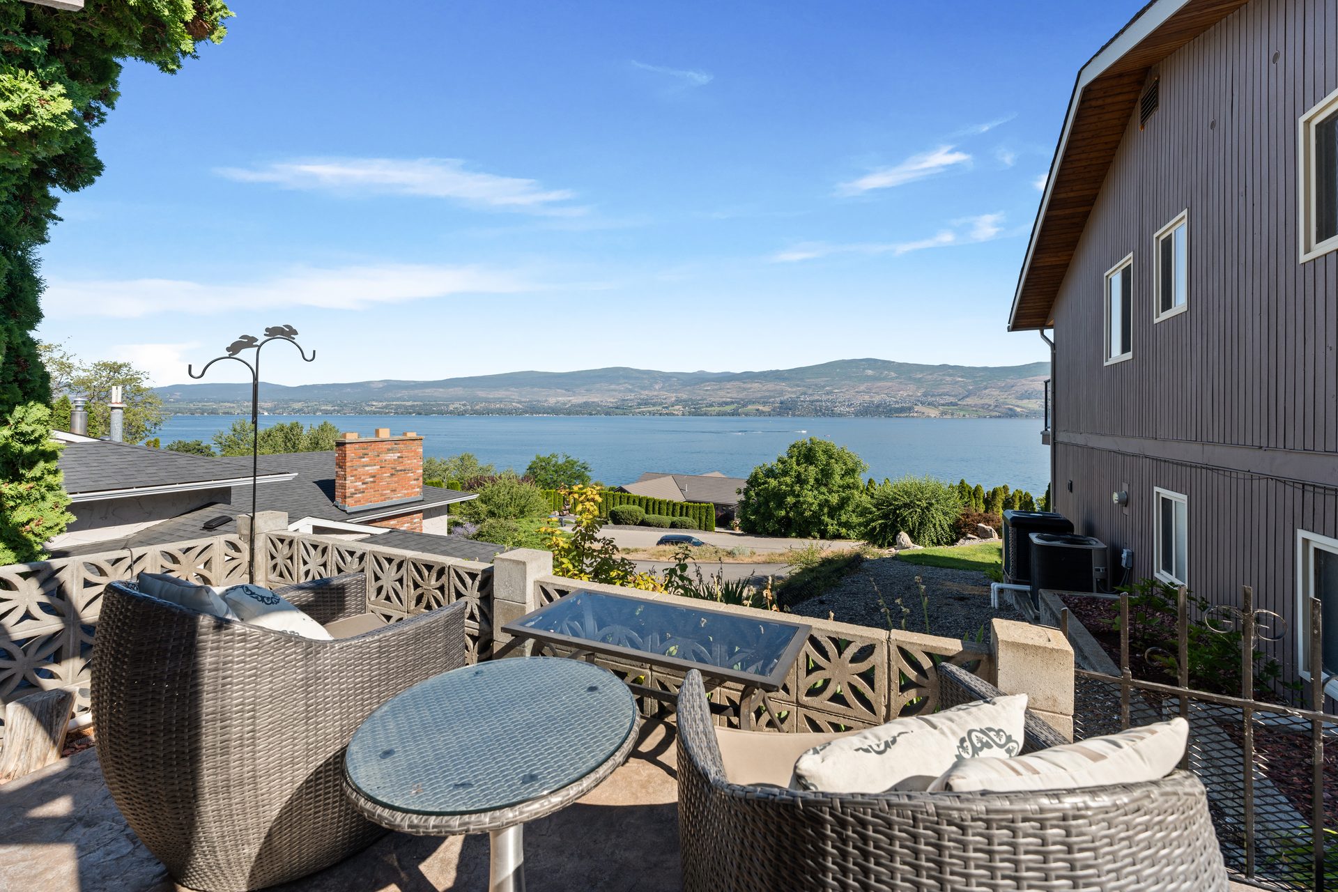 Wicker lounge seating area on lower patio with Okanagan Lake and mountain view